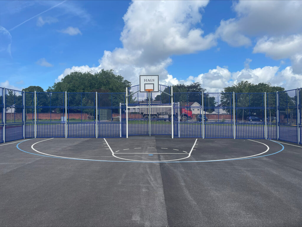 A view of the multi use games area on Springfield park showing a basketball hoop and goal.