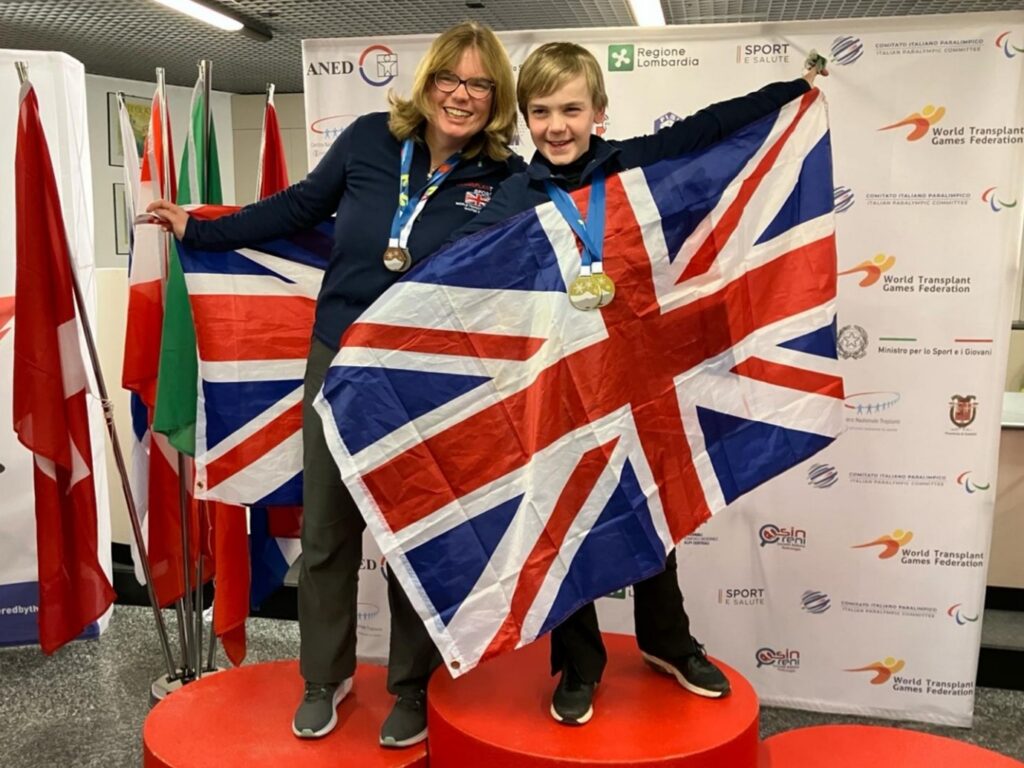 Alex and mum Julie holding Great Britain flags and wearing their medals
