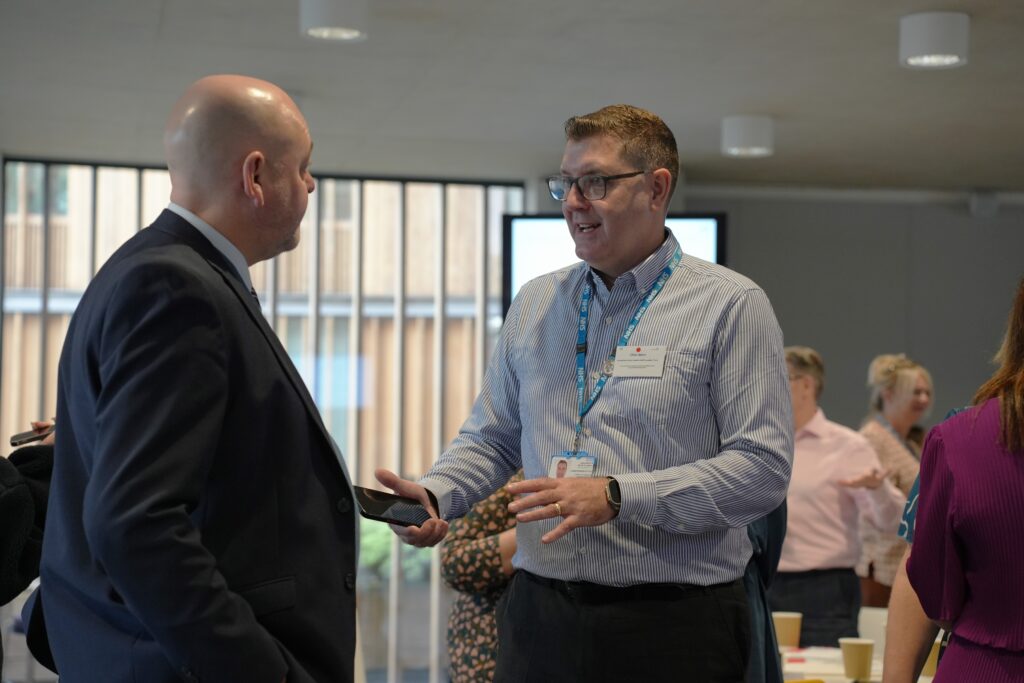 An image of two men talking during the event held at Alder Hey.