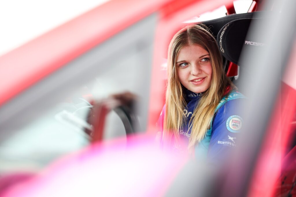 Daniella sitting in a race car