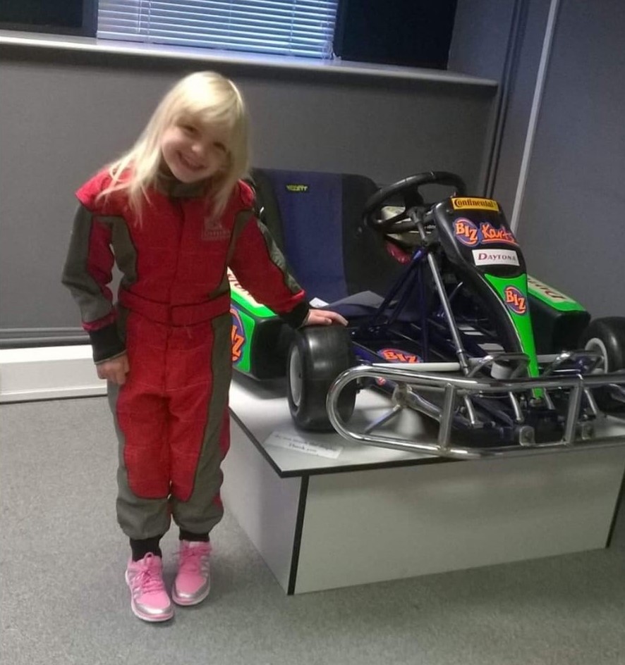 Daniella as a child stood next to a go kart