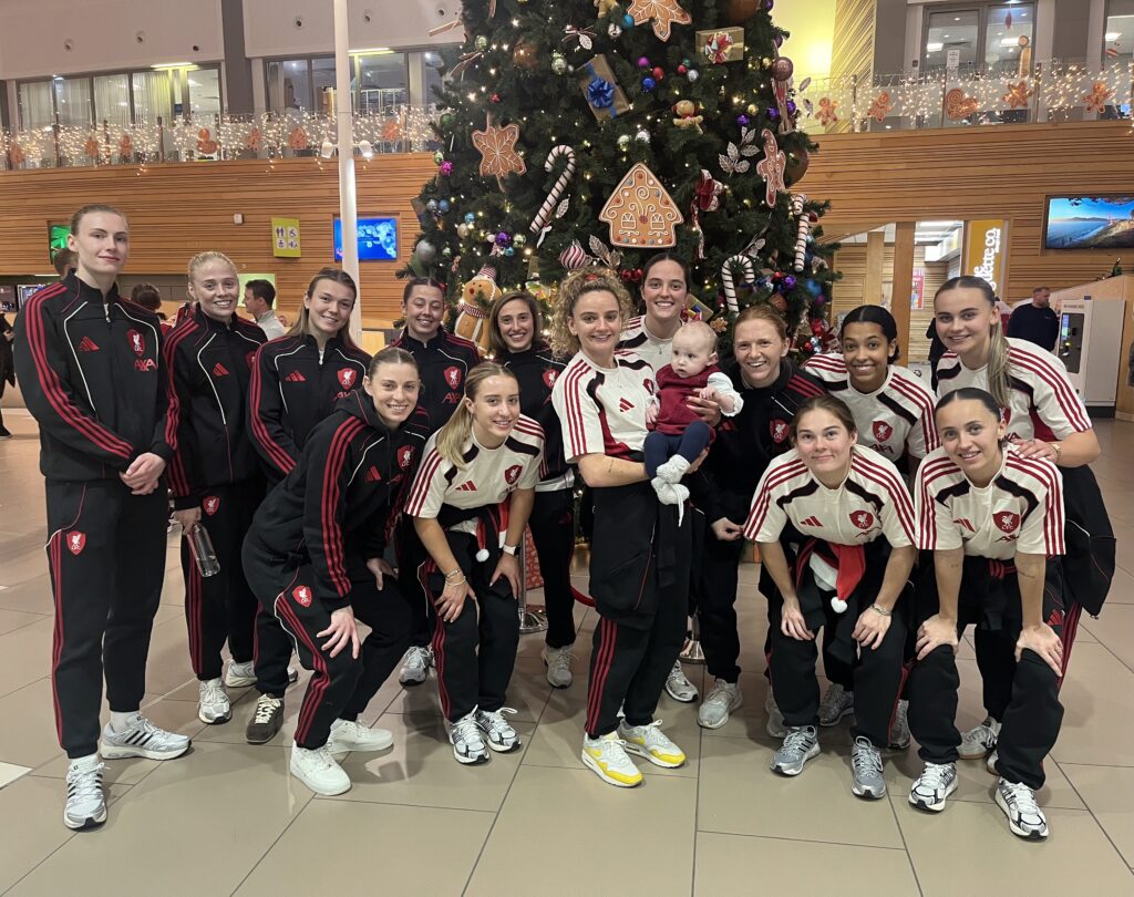 LFC Ladies players with an Alder Hey patient in front of a Christmas tree