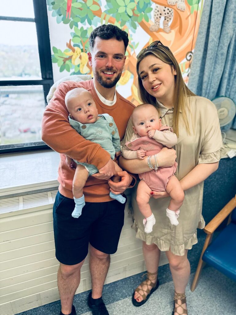 Photo of family holding two babies