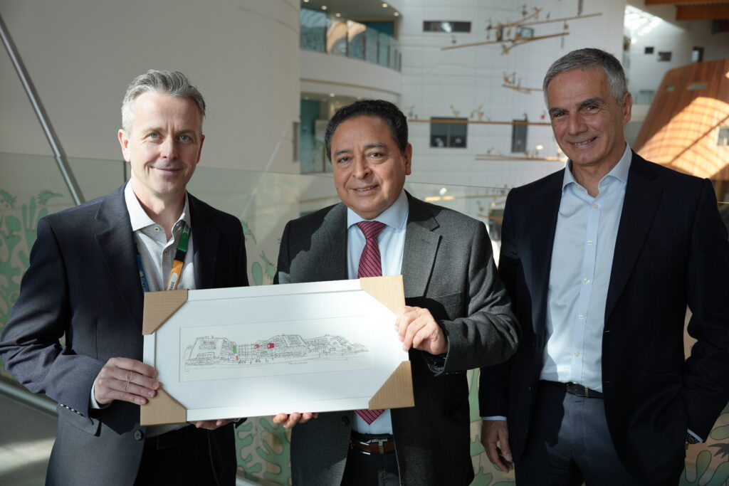 Photo of John Grinnell on the left presenting a framed drawing of Alder Hey Children's Hospital to the delegates from Peru. Rafael Guerrero on the right