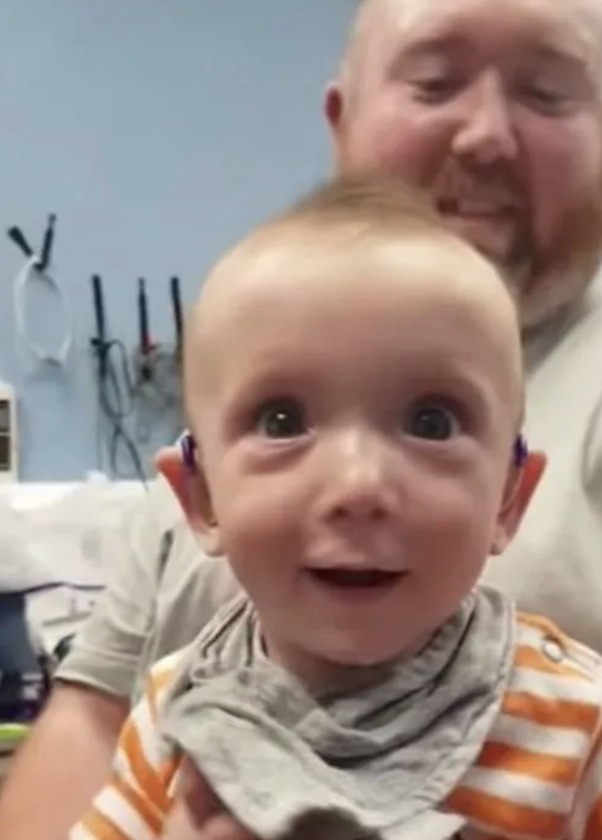 Baby Alex with his dad in the background