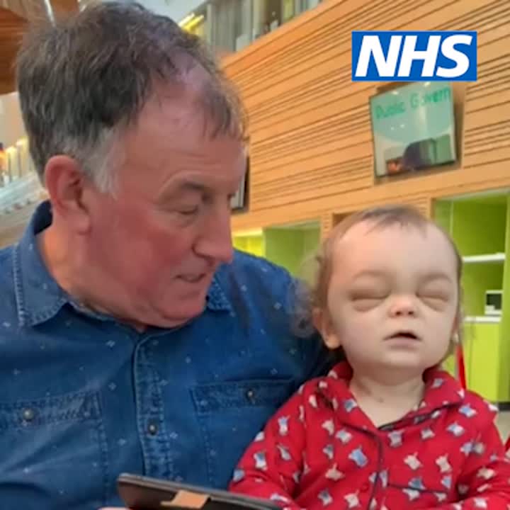 Child in red PJs next to man in blue shirt