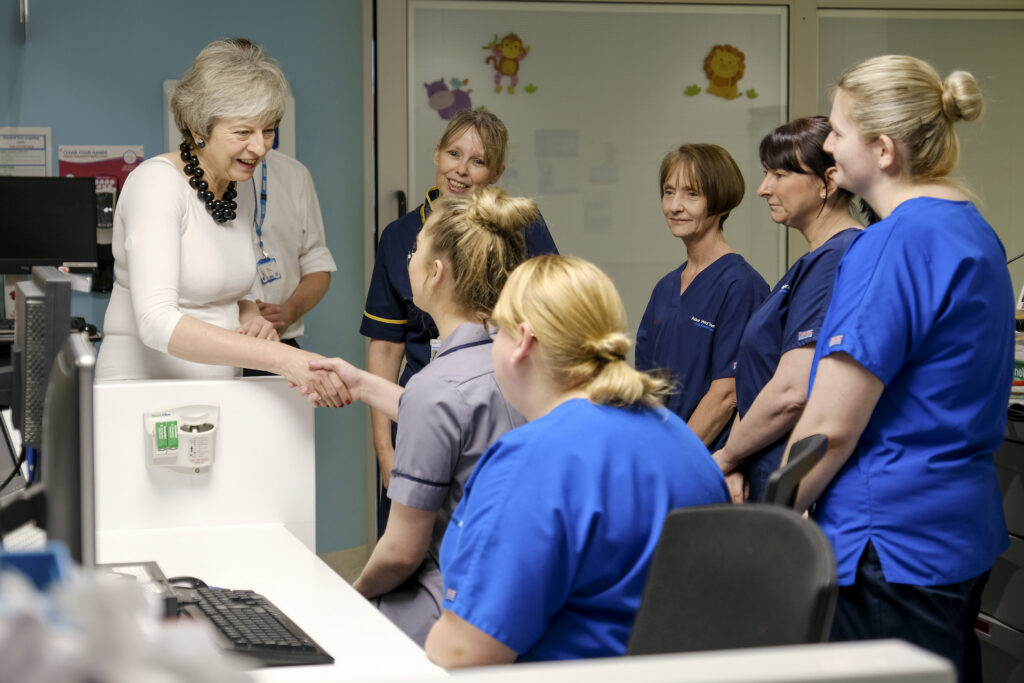 Prime Minister Theresa May speaking to Alder Hey nurses and shaking a hand