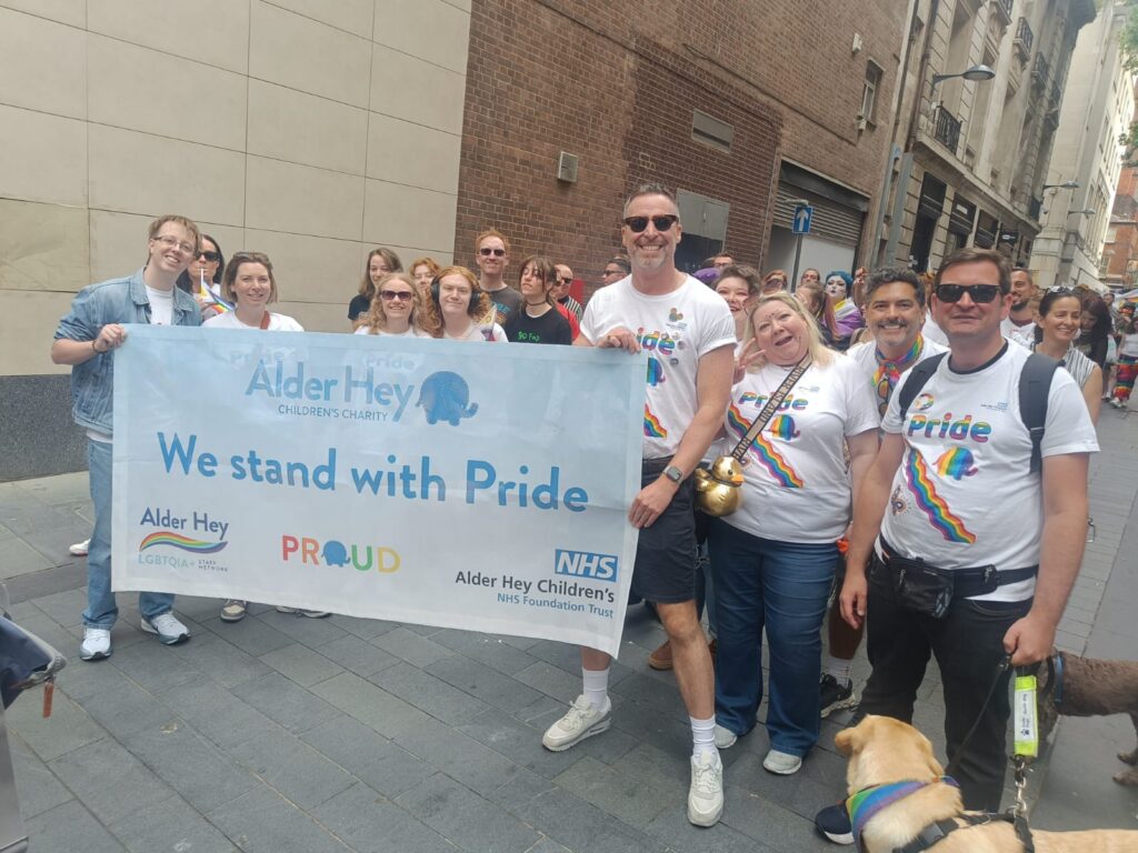 Group of people with a 'We Stand With Pride' banner