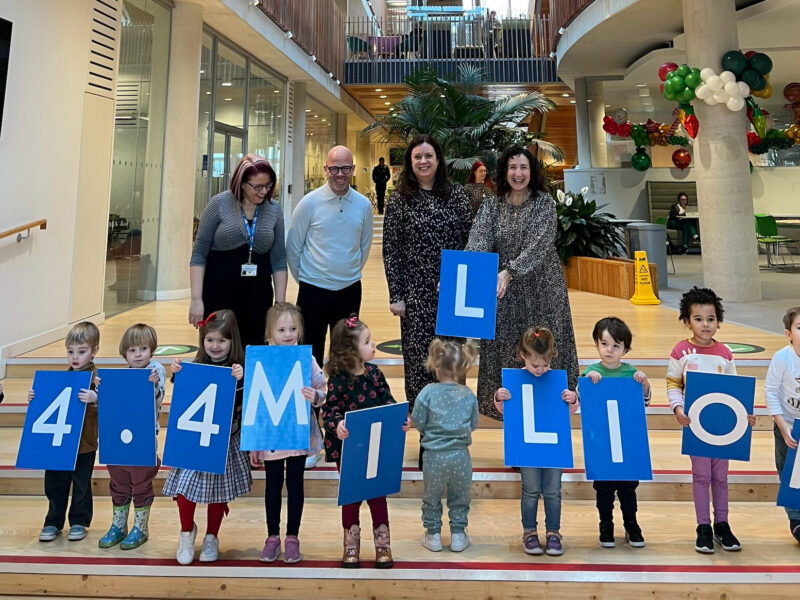 Alder Hey nursery kids hold up numbers and letters spelling out £4.4 million along with Alder Hey Charity and Matalan representatives