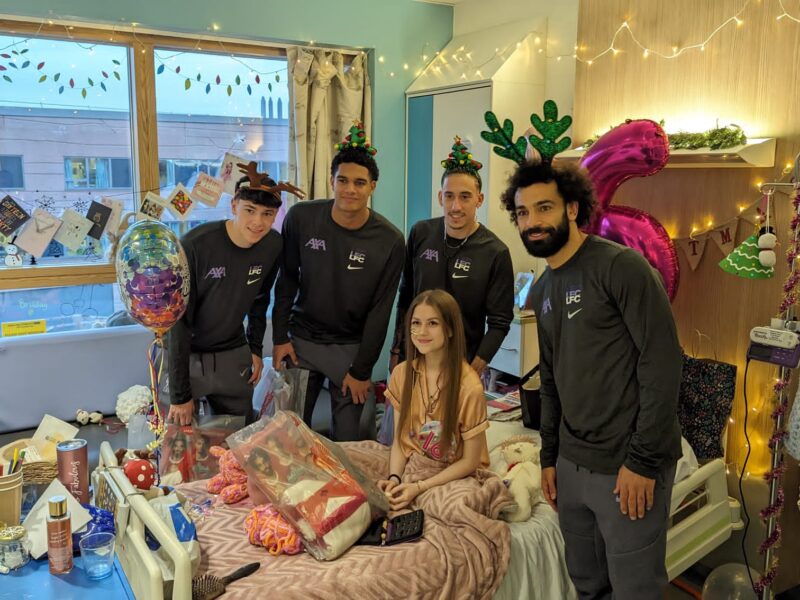 LFC players pose for a picture with a young girl at Alder Hey