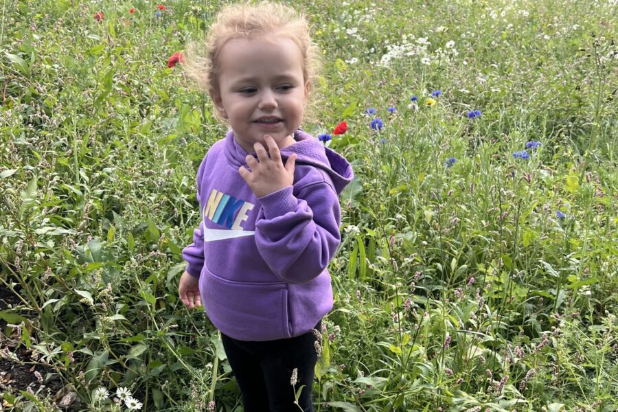 Esmai smelling the flowers