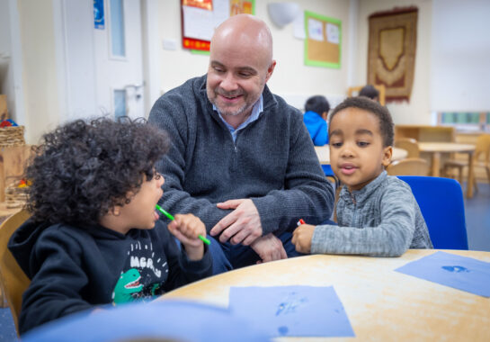 Photo of man and two children sitting and smiling