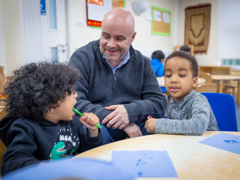 Photo of man and two children sitting and smiling