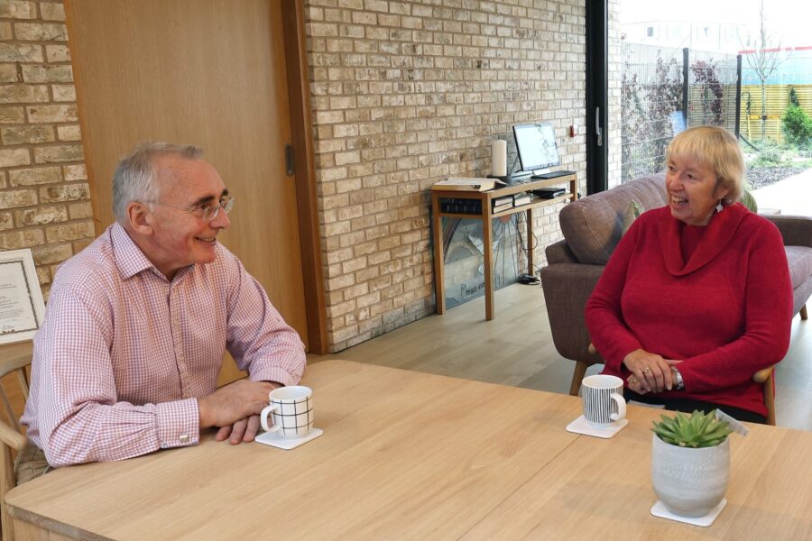 Two people sitting a table smiling