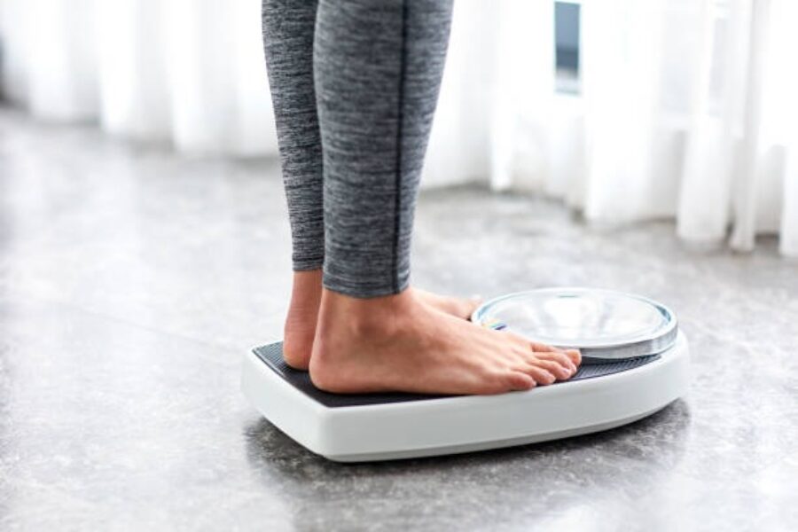 A stock image of a person standing on scales.
