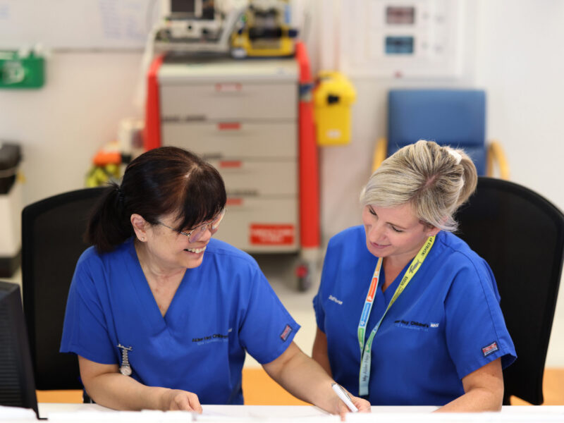 Photo of two nurses sitting down looking at a piece of paper