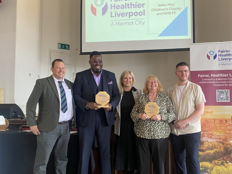 Group photo of people with an award. The background says Fairer Healthier Future