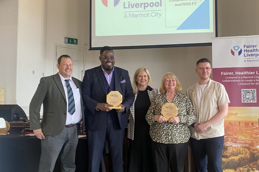 Group photo of people with an award. The background says Fairer Healthier Future