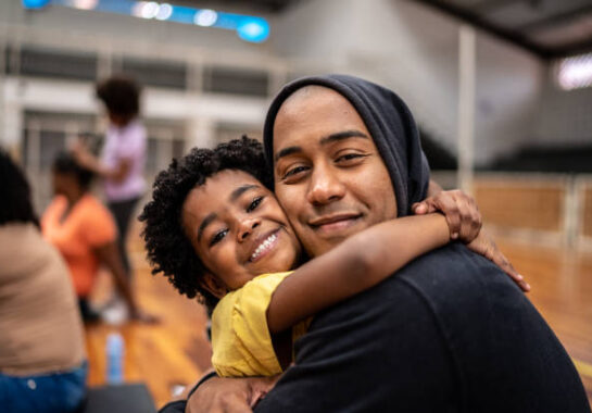 Portrait of father and daughter embracing at a community center