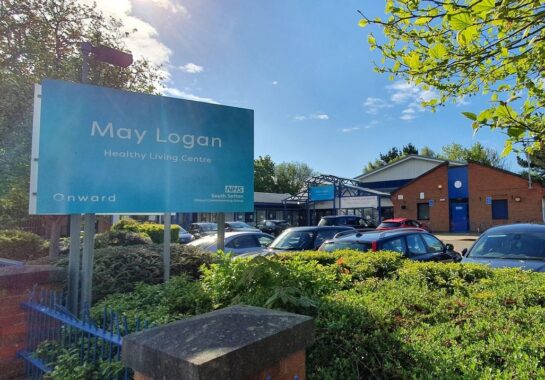A picture showing the external parking and the sign at May Logan Health Living Centre