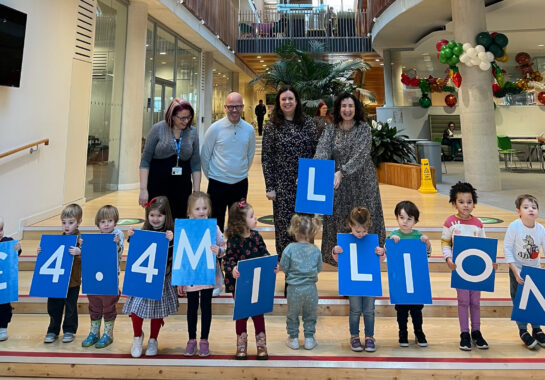 Alder Hey nursery kids hold up numbers and letters spelling out £4.4 million along with Alder Hey Charity and Matalan representatives