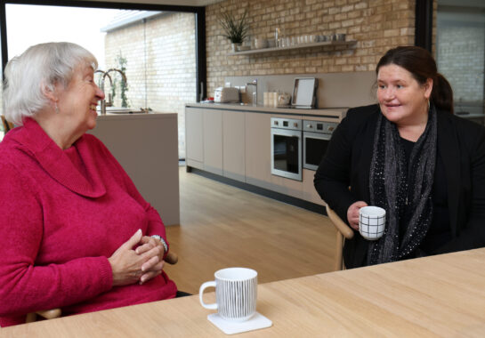Two people talking over a cup of tea in the Alder Centre